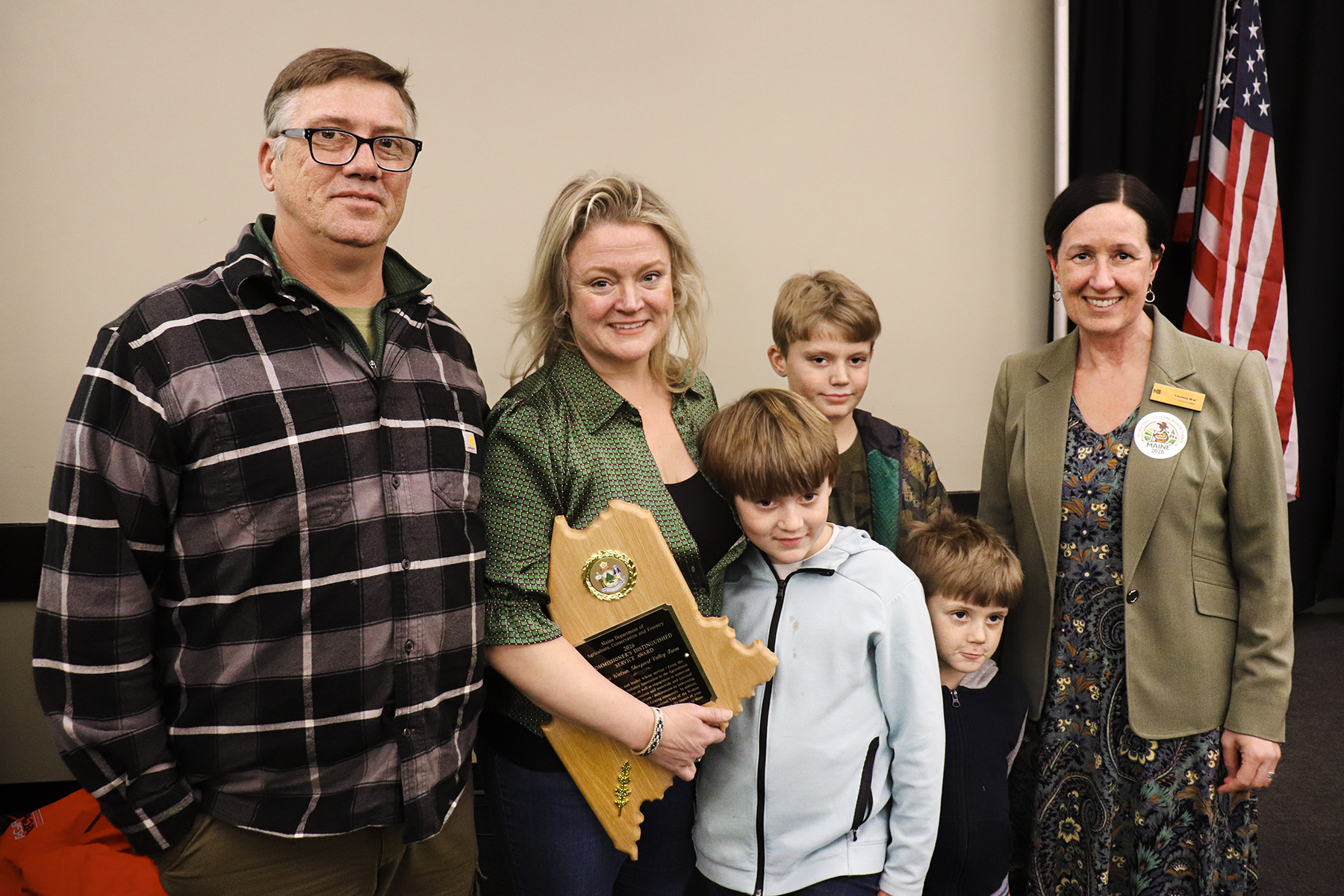 Annie Watson is pictured with her husband, Michael Moody, and their sons following her acceptance remarks today, reflecting the family-centered nature of Maine agriculture.