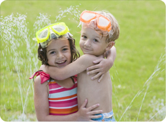 kids staying cool in sprinkler